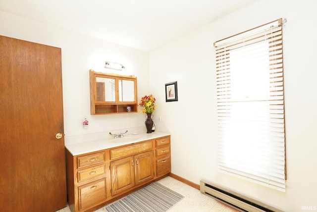 bathroom featuring tile patterned floors, vanity, a baseboard heating unit, and baseboards