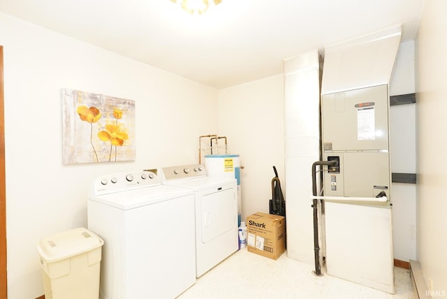 clothes washing area with light floors, water heater, laundry area, heating unit, and independent washer and dryer