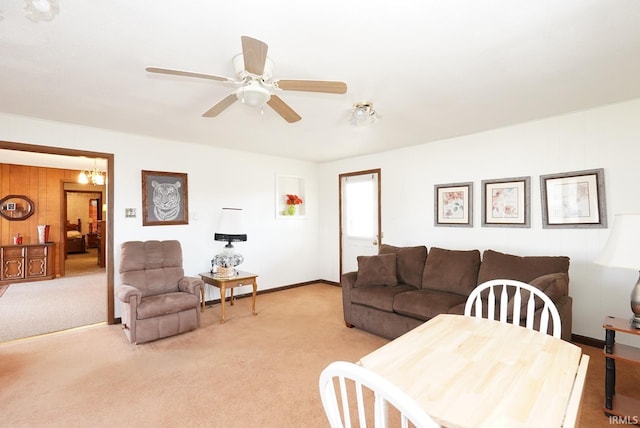 living room featuring light carpet, wood walls, and ceiling fan