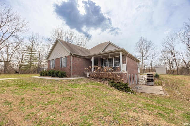 view of property exterior featuring brick siding, stairway, a lawn, and a patio area