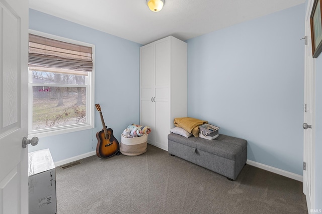 living area with visible vents, baseboards, and carpet