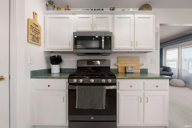 kitchen featuring dark countertops, white cabinets, and stainless steel appliances