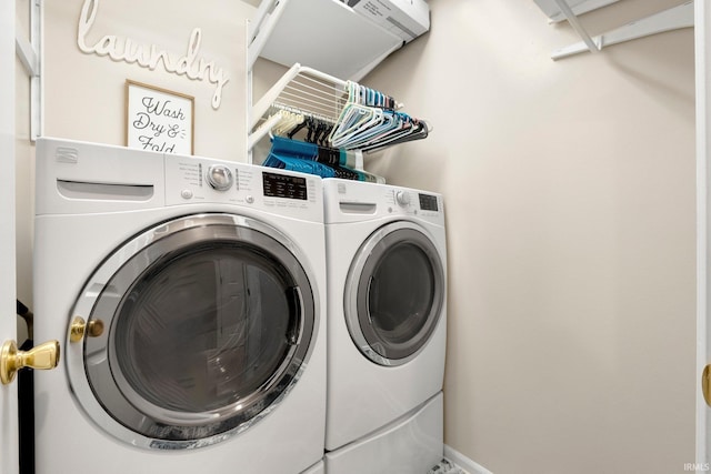 clothes washing area featuring laundry area, washing machine and dryer, and baseboards