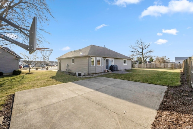 back of house featuring a patio area, a lawn, and fence