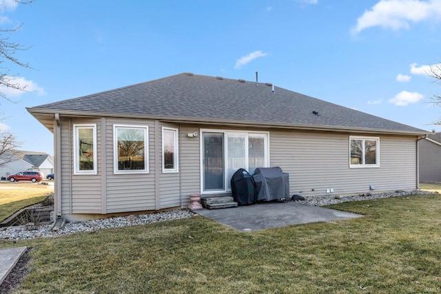 rear view of property featuring entry steps, a patio, a yard, and a shingled roof