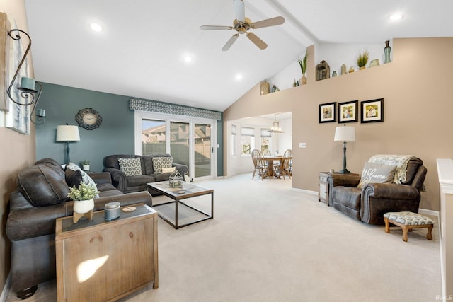 living area featuring baseboards, beamed ceiling, light colored carpet, ceiling fan with notable chandelier, and high vaulted ceiling