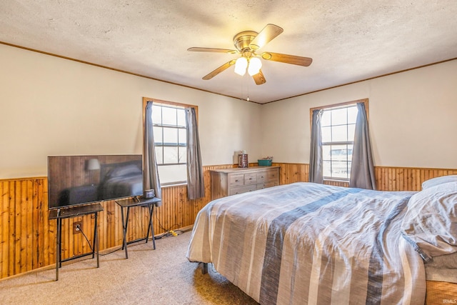 bedroom with wooden walls, multiple windows, and wainscoting