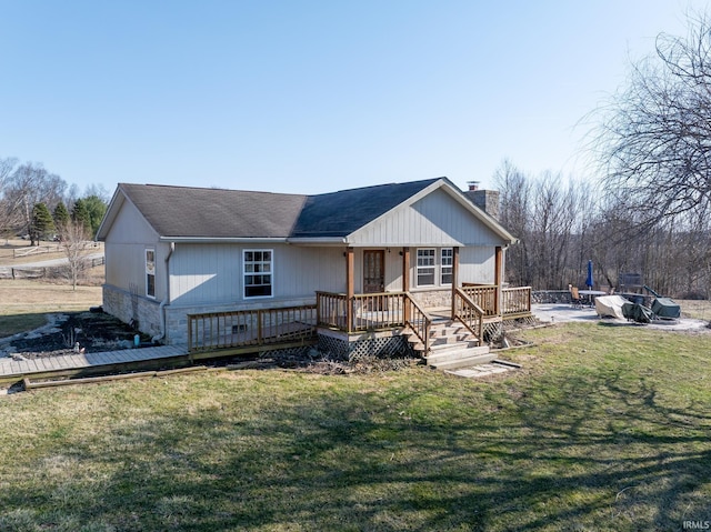 view of front facade featuring a wooden deck, a chimney, and a front lawn