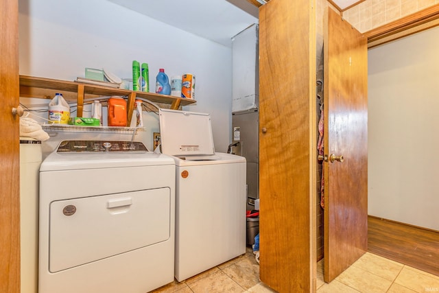 laundry area featuring washing machine and clothes dryer, laundry area, and light tile patterned flooring