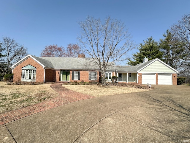 single story home featuring a garage, driveway, brick siding, and a chimney