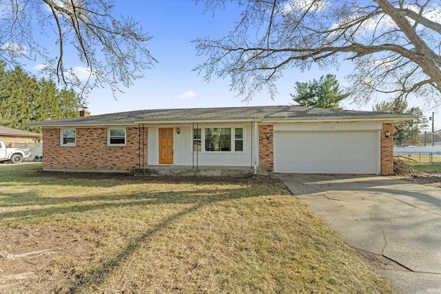 single story home featuring concrete driveway, a front yard, a garage, brick siding, and a chimney