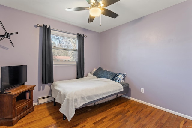 bedroom with light wood-style flooring, baseboards, baseboard heating, and ceiling fan