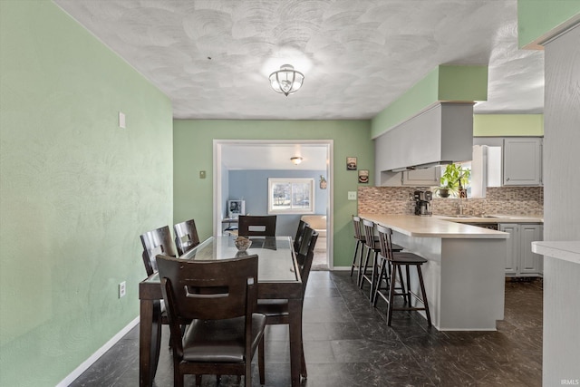 dining area featuring baseboards and a textured ceiling