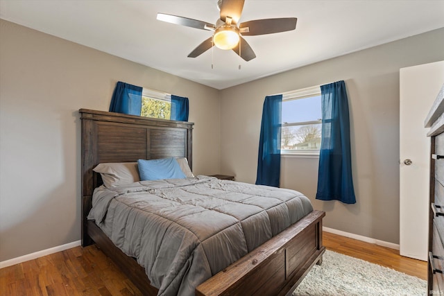 bedroom featuring ceiling fan, baseboards, and wood finished floors