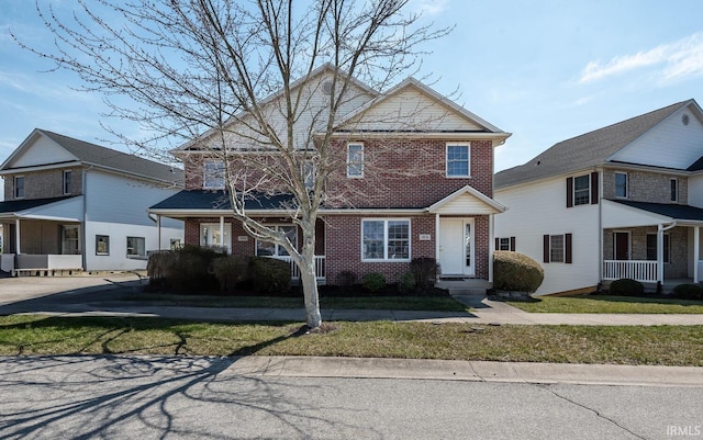 view of front of house with brick siding and a front lawn