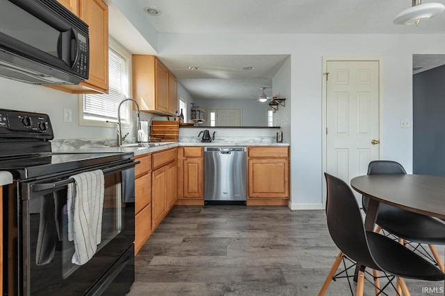 kitchen featuring dark wood-style flooring, a sink, ceiling fan, black appliances, and light countertops