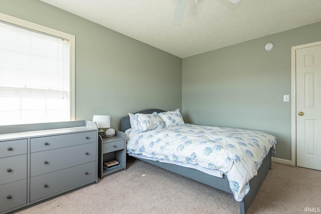 bedroom featuring light colored carpet and ceiling fan