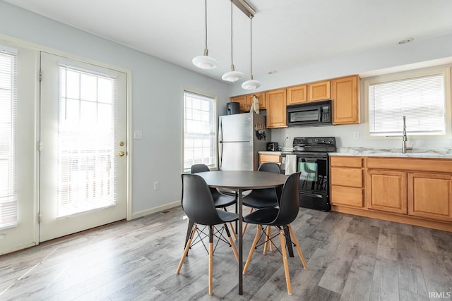 dining area featuring baseboards and light wood-type flooring