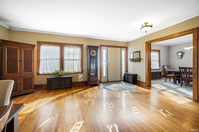 foyer featuring baseboards, wood finished floors, radiator heating unit, and ornamental molding