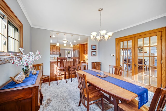 dining area with a notable chandelier, light colored carpet, and ornamental molding