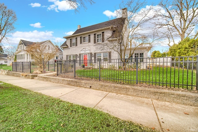 colonial-style house with a fenced front yard, a chimney, and a front yard