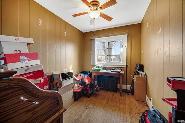 interior space with radiator heating unit, a ceiling fan, and hardwood / wood-style floors