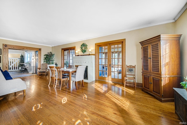 dining room with wood finished floors, french doors, and ornamental molding