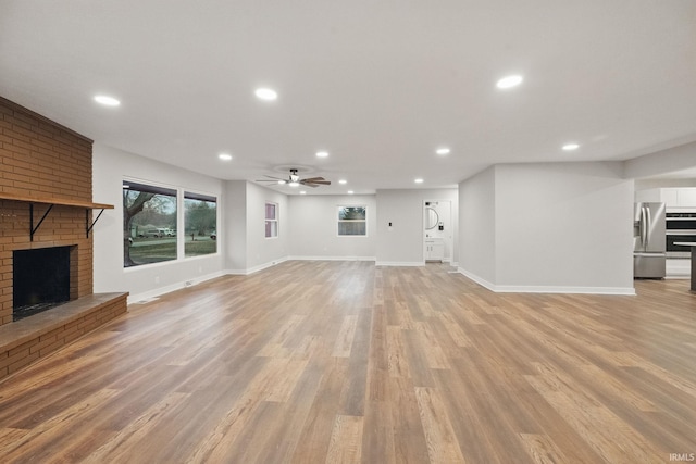 unfurnished living room featuring a ceiling fan, light wood-style flooring, recessed lighting, and a fireplace