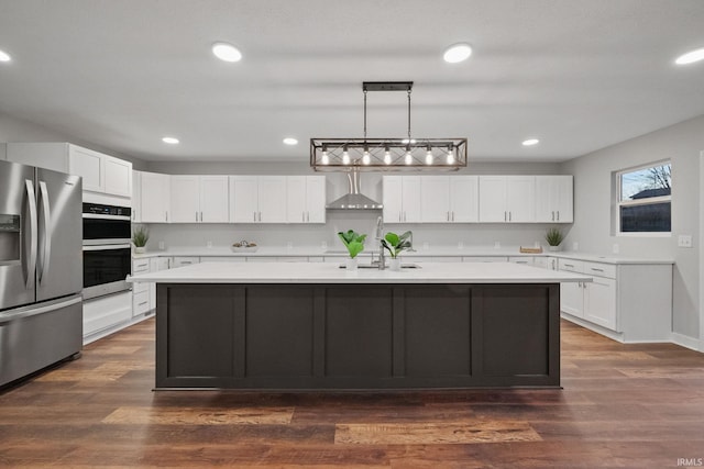 kitchen with white cabinetry, appliances with stainless steel finishes, light countertops, and wall chimney exhaust hood