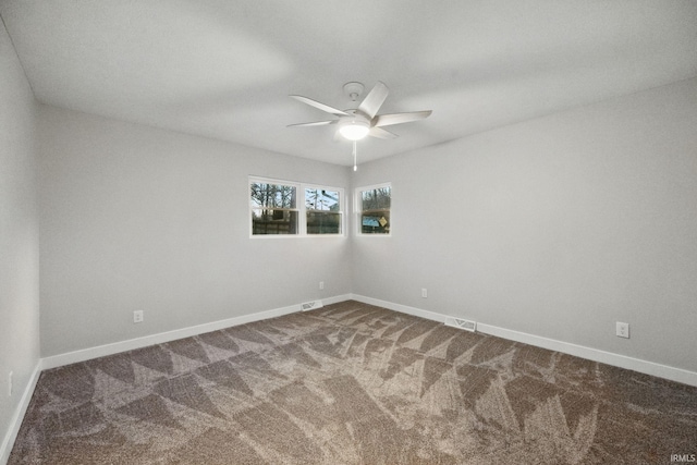 spare room featuring carpet flooring, visible vents, baseboards, and ceiling fan