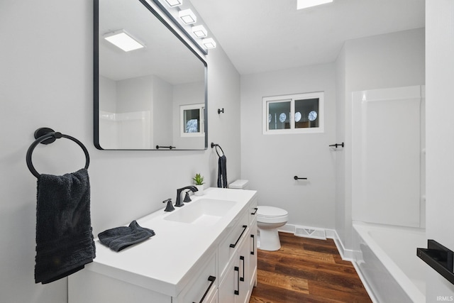 bathroom with visible vents, baseboards, toilet, wood finished floors, and vanity