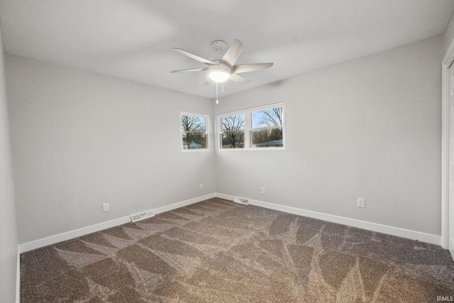 unfurnished room featuring dark colored carpet, visible vents, baseboards, and ceiling fan