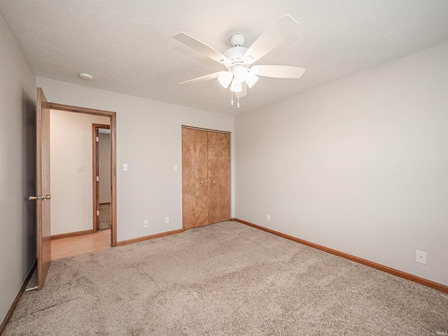 unfurnished bedroom with a ceiling fan, carpet, baseboards, a closet, and a textured ceiling