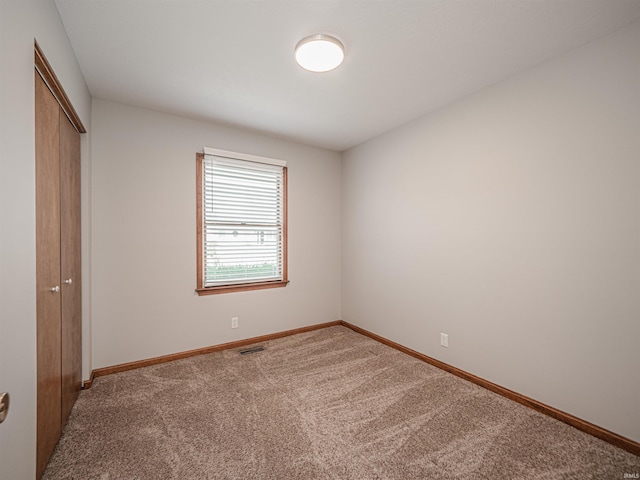 unfurnished bedroom with a closet, carpet flooring, visible vents, and baseboards