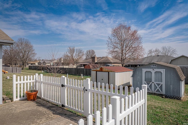 view of yard with a shed, fence private yard, an outdoor structure, and a gate