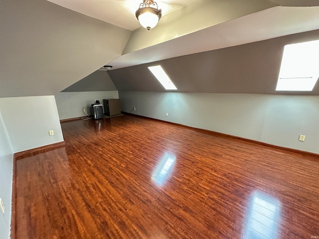 additional living space featuring vaulted ceiling, baseboards, and hardwood / wood-style floors