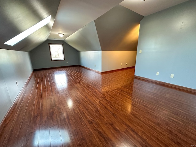 additional living space featuring lofted ceiling, wood finished floors, and baseboards