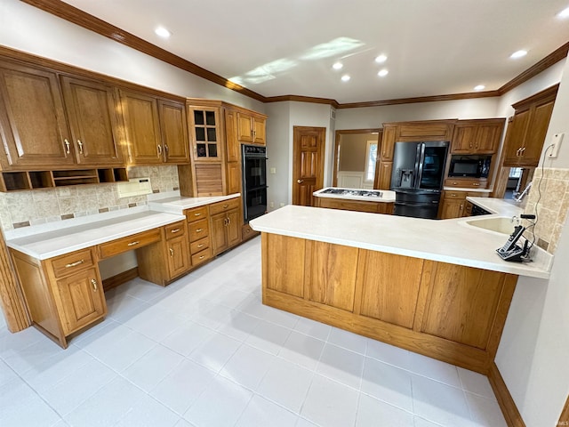 kitchen with brown cabinetry, a sink, black appliances, light countertops, and tasteful backsplash