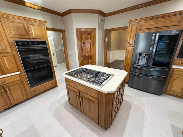 kitchen featuring brown cabinetry, visible vents, black appliances, and light countertops