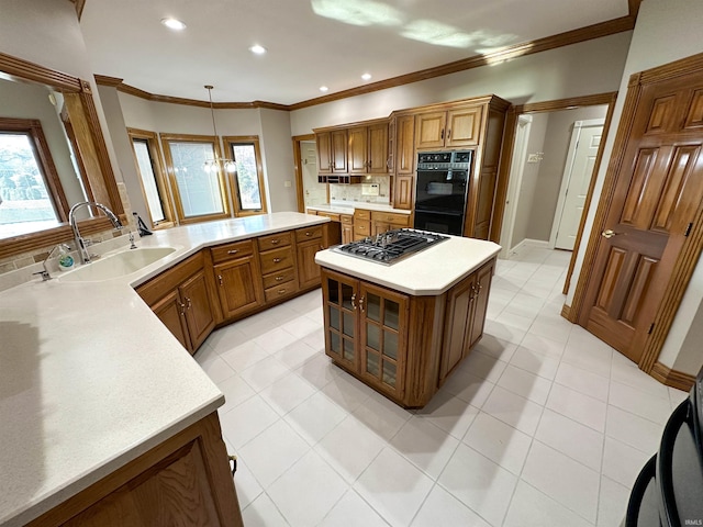 kitchen with brown cabinetry, tasteful backsplash, stovetop with downdraft, and a sink