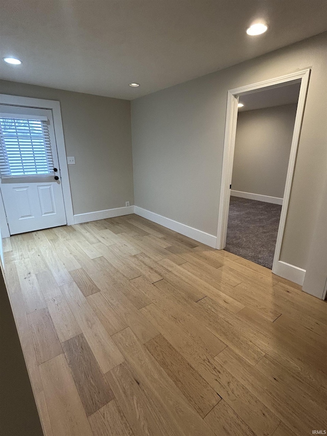 unfurnished room with light wood finished floors, recessed lighting, and baseboards