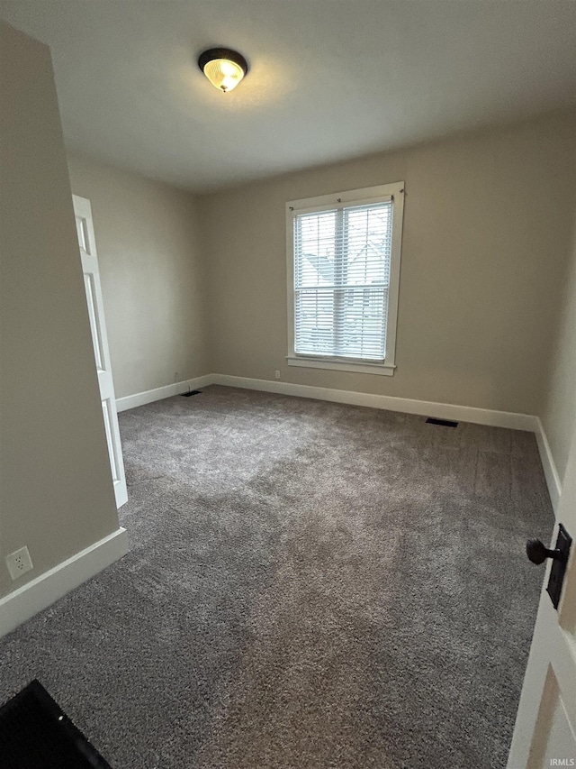 empty room featuring visible vents, baseboards, and carpet floors