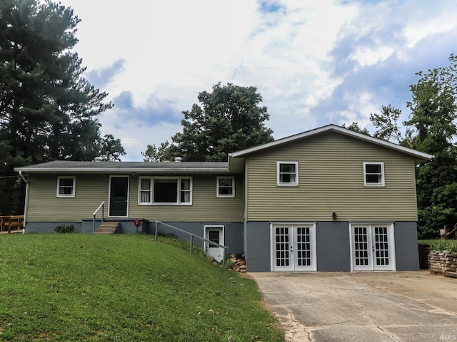 rear view of property featuring french doors, a yard, and entry steps