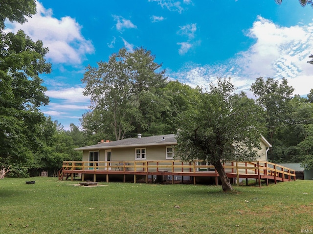 back of house with a deck and a lawn