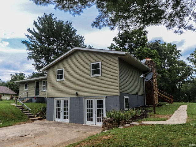 rear view of house with stairs, a patio area, french doors, and a lawn
