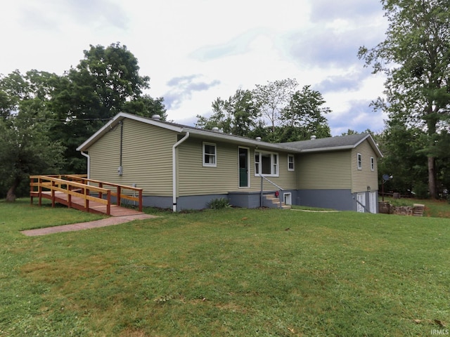 rear view of house with an attached garage and a lawn