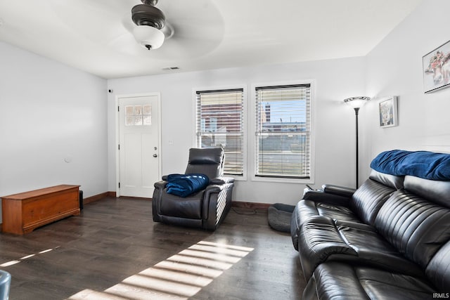 living room with visible vents, wood finished floors, baseboards, and ceiling fan