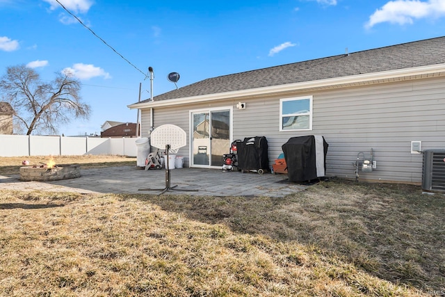 rear view of property featuring a patio, fence, an outdoor fire pit, a yard, and central air condition unit