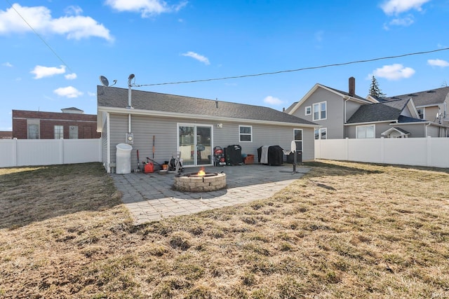 rear view of property with a patio, a fire pit, a lawn, and a fenced backyard