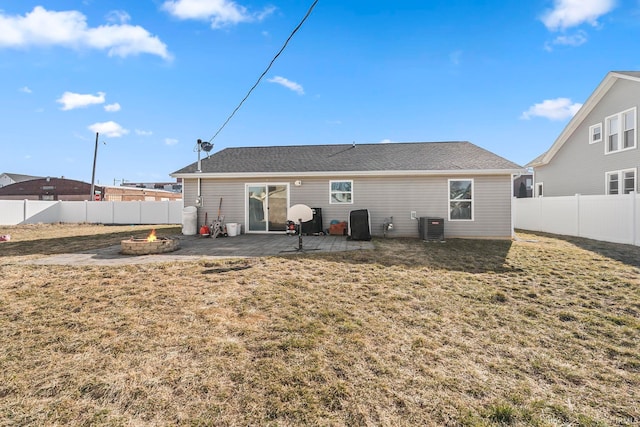 back of house featuring a fire pit, central AC, a fenced backyard, a yard, and a patio area